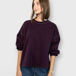 JONES + CO Fond sweatshirt in plum featuring a crewneck, drop shoulders, cropped sleeves, and a raw edge hemline.
