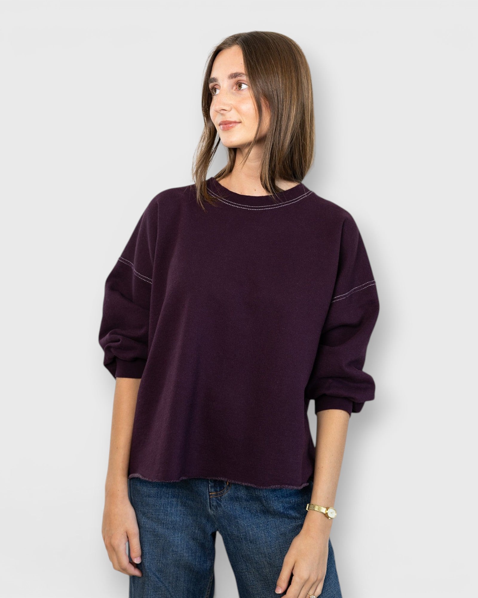 JONES + CO Fond sweatshirt in plum featuring a crewneck, drop shoulders, cropped sleeves, and a raw edge hemline.