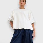 Model wearing JONES + CO Fond crewneck sweatshirt in dirty white with drop shoulders and raw edge hemline.