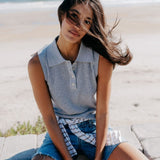 JONES + CO Fran Polo Tank in heather grey pointelle knit. Sleeveless, collared, button-up front. Model wears with denim shorts.