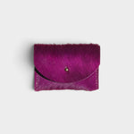 JONES + CO fuchsia cowhide cardholder with a solid brass fastener, featuring a textured hair-on-hide finish.