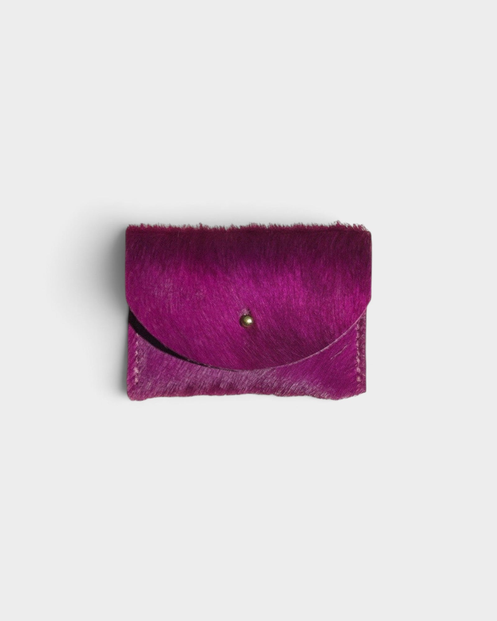 JONES + CO fuchsia cowhide cardholder with a solid brass fastener, featuring a textured hair-on-hide finish.