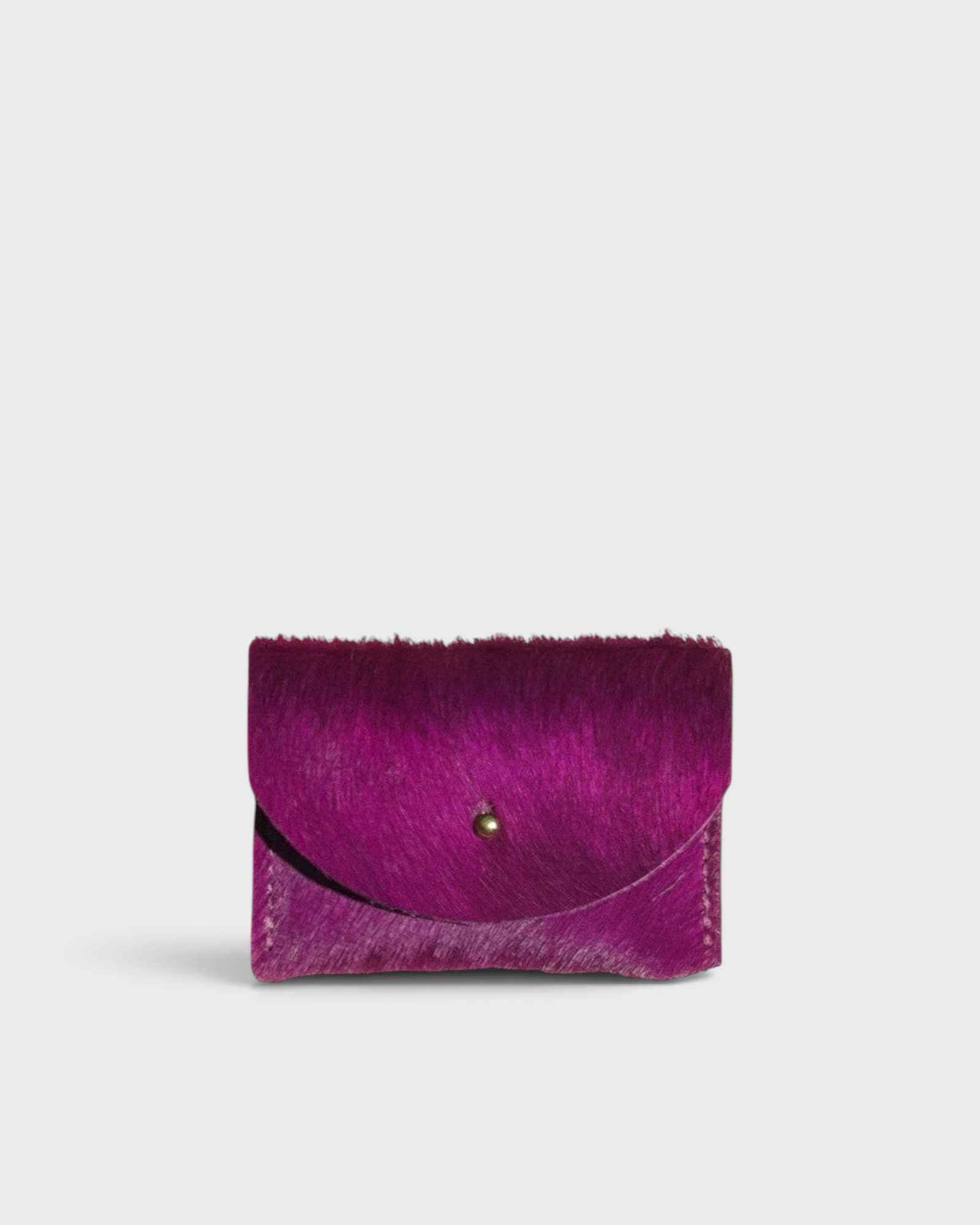 JONES + CO fuchsia cowhide cardholder with a solid brass fastener, featuring a textured hair-on-hide finish.