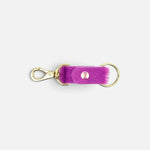 JONES + CO fuchsia cowhide keychain with gold-tone metal clasp and ring on a plain background