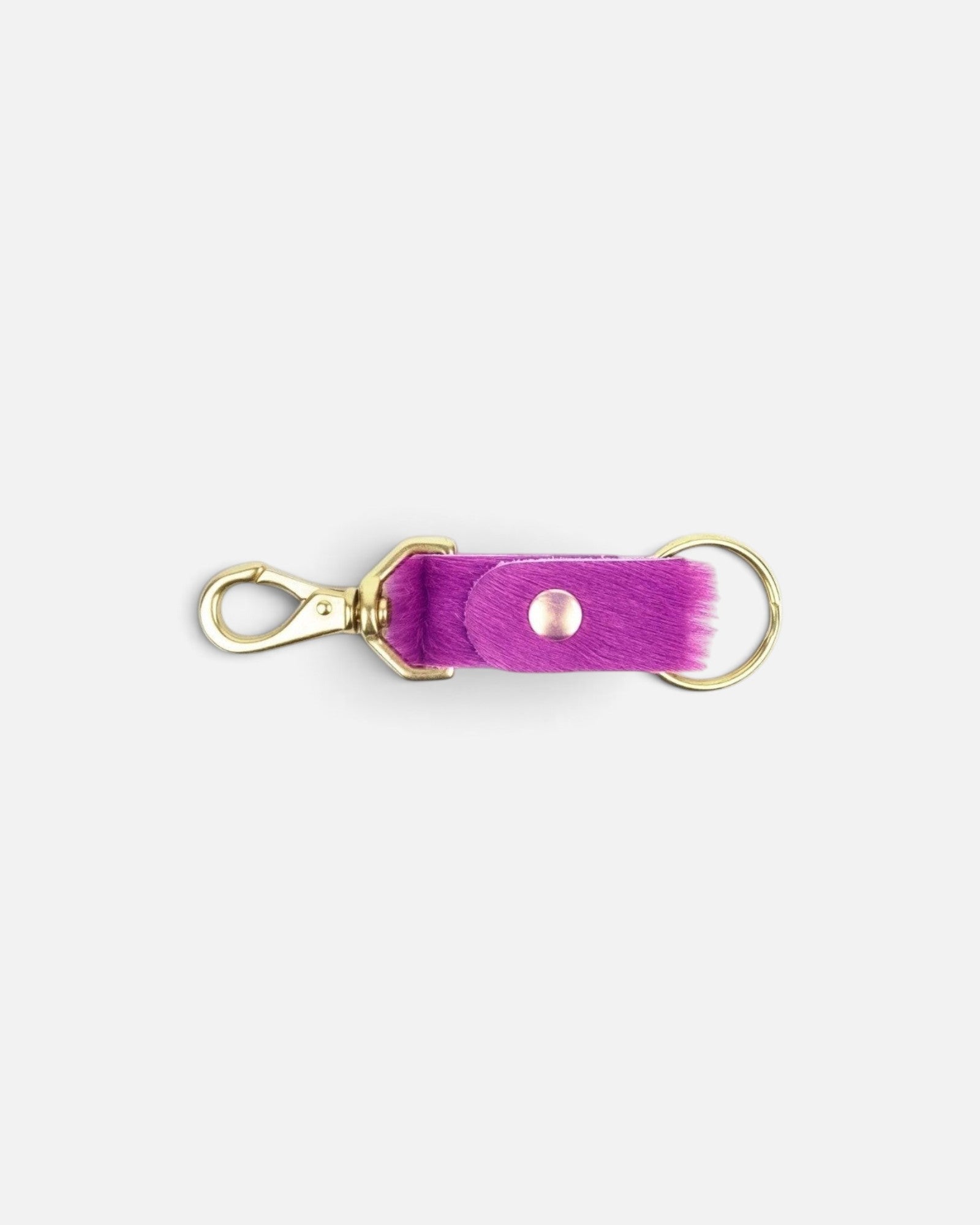 JONES + CO fuchsia cowhide keychain with gold-tone metal clasp and ring on a plain background