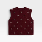 JONES + CO Vega knit vest in garnet red with a boxy silhouette, crew neckline, and metallic eyelet hardware.
