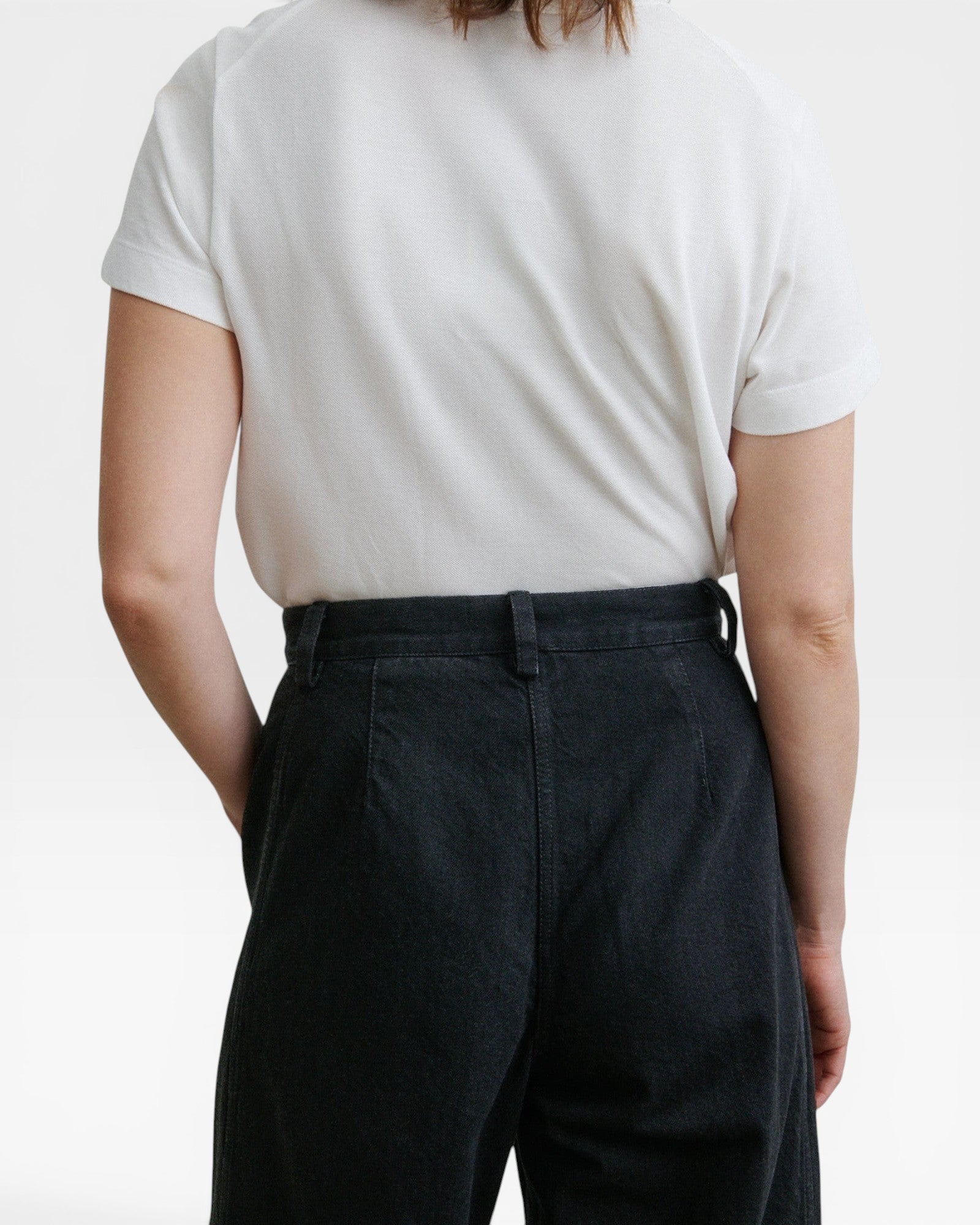 Back view of JONES + CO Garra Pant in black denim with a high-waisted, relaxed fit and contrast side panels.