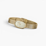 JONES + CO Jane Small watch with a gold oval case, champagne mother of pearl dial, and woven mesh bracelet.