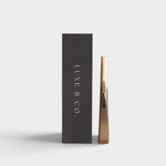 JONES + CO gold rechargeable USB arc lighter standing next to its sleek black presentation box