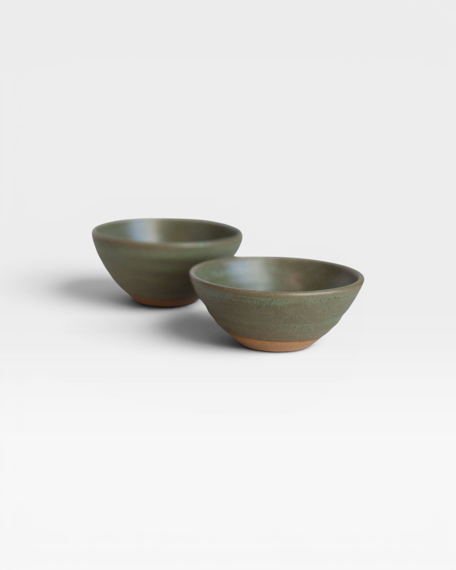 JONES + CO handcrafted green ceramic little bowls with a rustic exposed clay base for home decor or serving snacks.