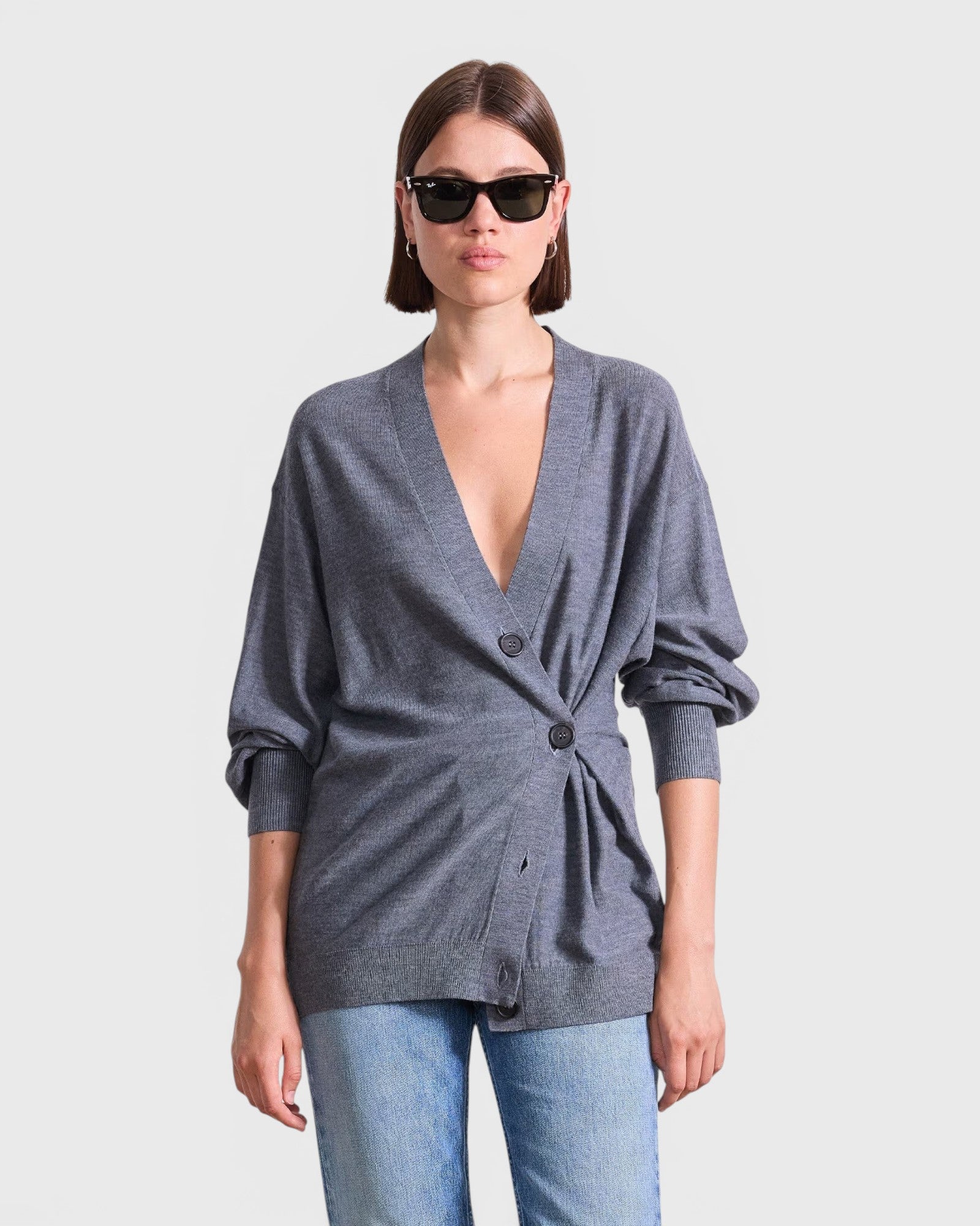 JONES + CO grey lightweight tissue cardigan with a side-cinched button detail worn by a woman in sunglasses.
