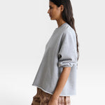 JONES + CO Rachel Comey grey crewneck sweatshirt with drop shoulders and raw edge hem worn by a model