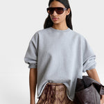 JONES + CO model wearing a grey Rachel Comey Fond crewneck sweatshirt with drop shoulders and raw edge hemline.