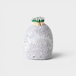 JONES + CO hand-drilled grey beach stone match striker filled with green-tipped matches on a neutral background