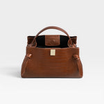 JONES + CO Gyoza pouch in brown embossed leather with a structured silhouette and gold-tone hardware clasp.