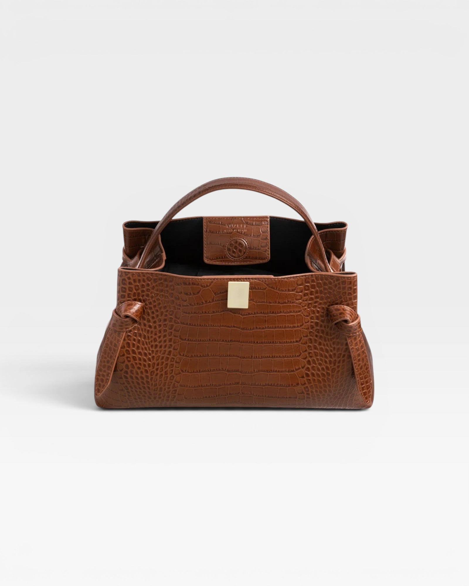 JONES + CO Gyoza pouch in brown embossed leather with a structured silhouette and gold-tone hardware clasp.