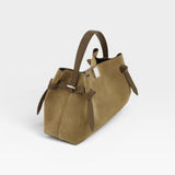 JONES + CO Gyoza pouch in fennel suede with a structured handle and side knot details on a white background.