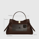 JONES + CO Gyoza pouch in Sierra embossed brown leather with a gold clasp and iPhone 16 Pro Max for size reference.