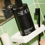 JONES + CO black matte bottle of The Hand Exfoliant with bergamot and vetiver scent, featuring fine perlite and rambutan.