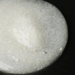JONES + CO The Hand Exfoliant with fine perlite and rambutan, clear gel with white beads and bubbles.