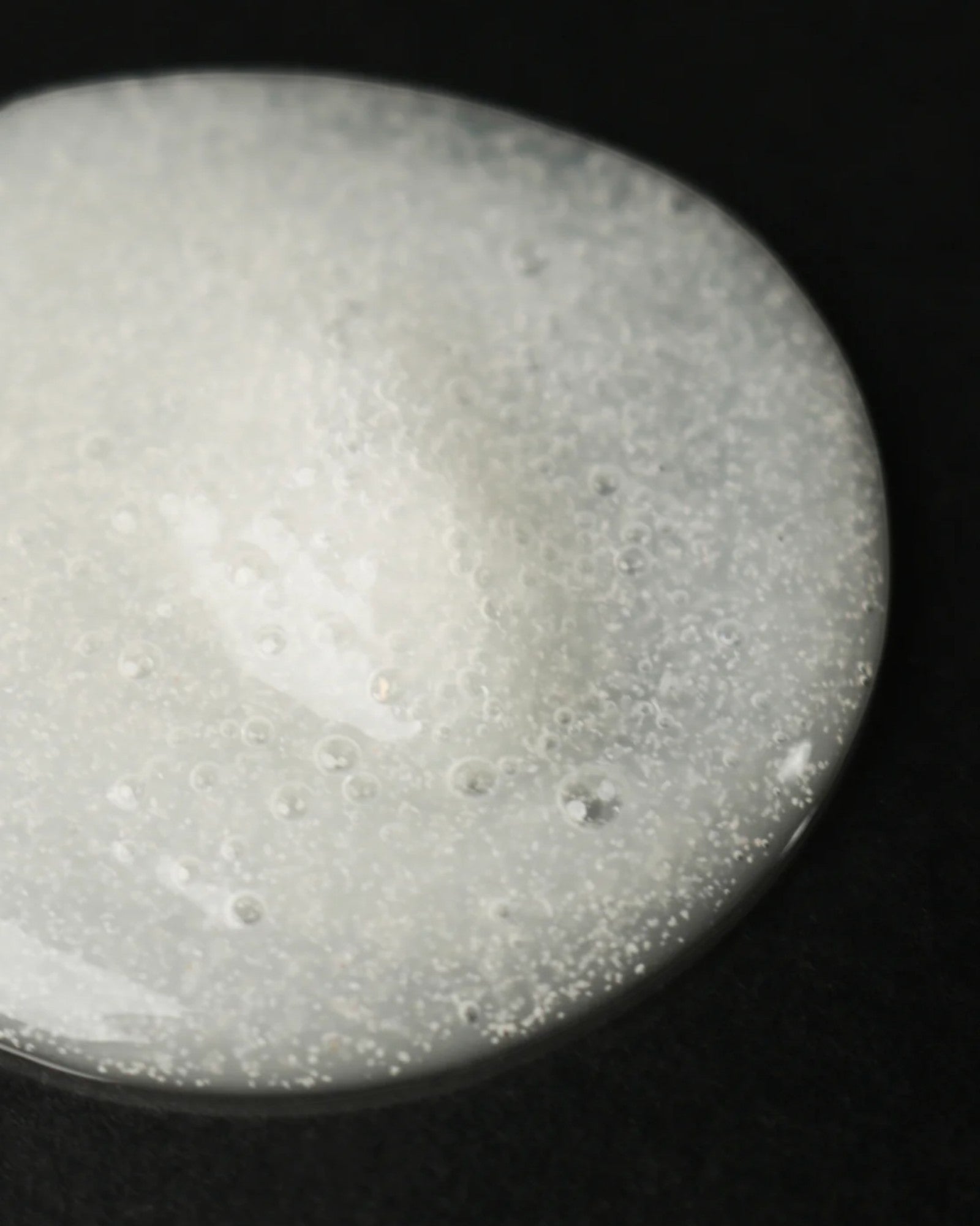 JONES + CO The Hand Exfoliant with fine perlite and rambutan, clear gel with white beads and bubbles.