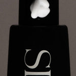 JONES + CO The Hand Serum in Nirvana, a black bottle with white lettering and a dollop of white serum on top.