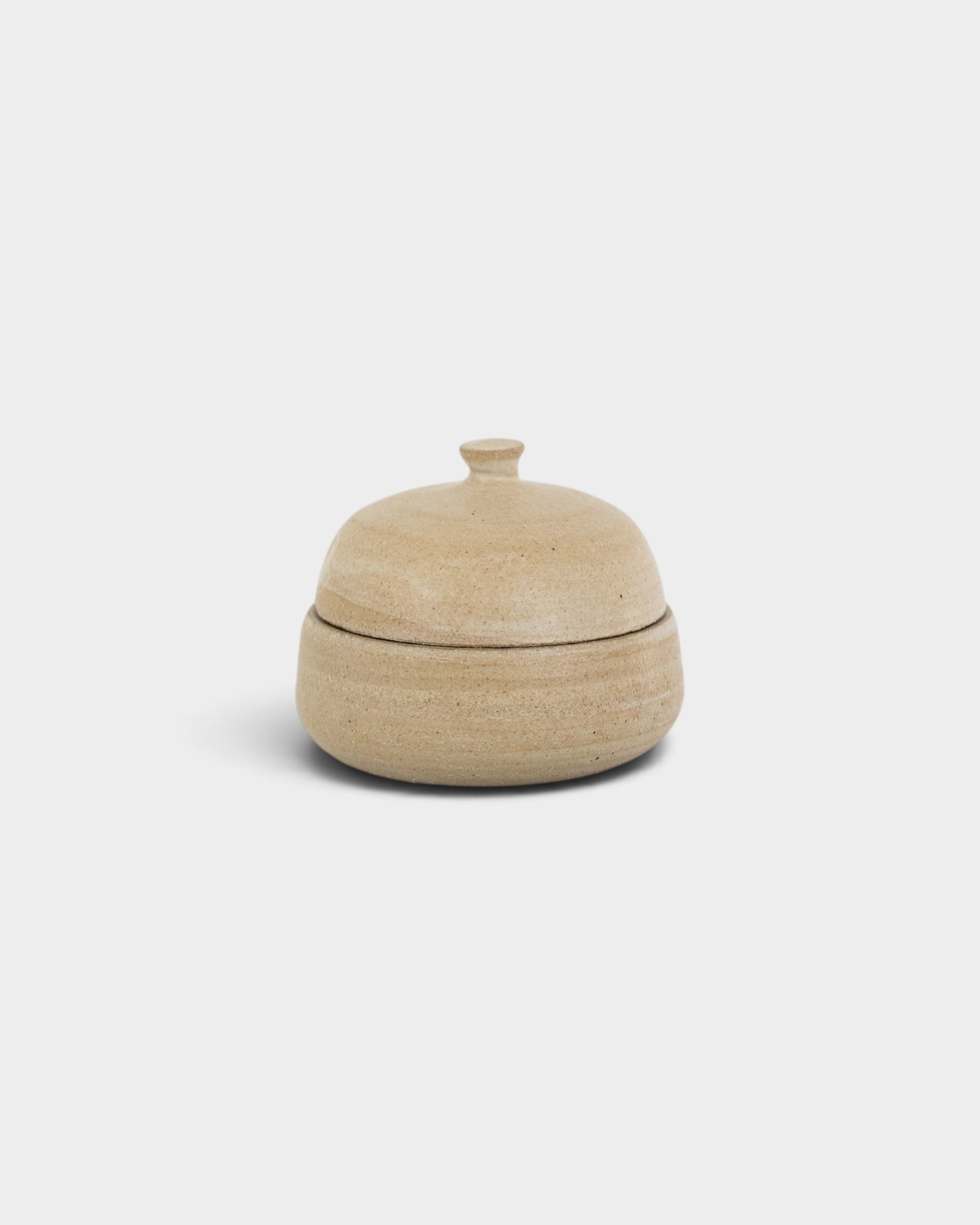 JONES + CO handthrown ceramic jar in a natural beige speckled finish with a small lid for storage.
