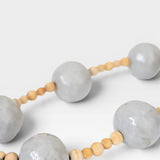 JONES + CO handcrafted wall art with large grey pottery beads and small wooden beads, bringing spiritual elegance to any space.