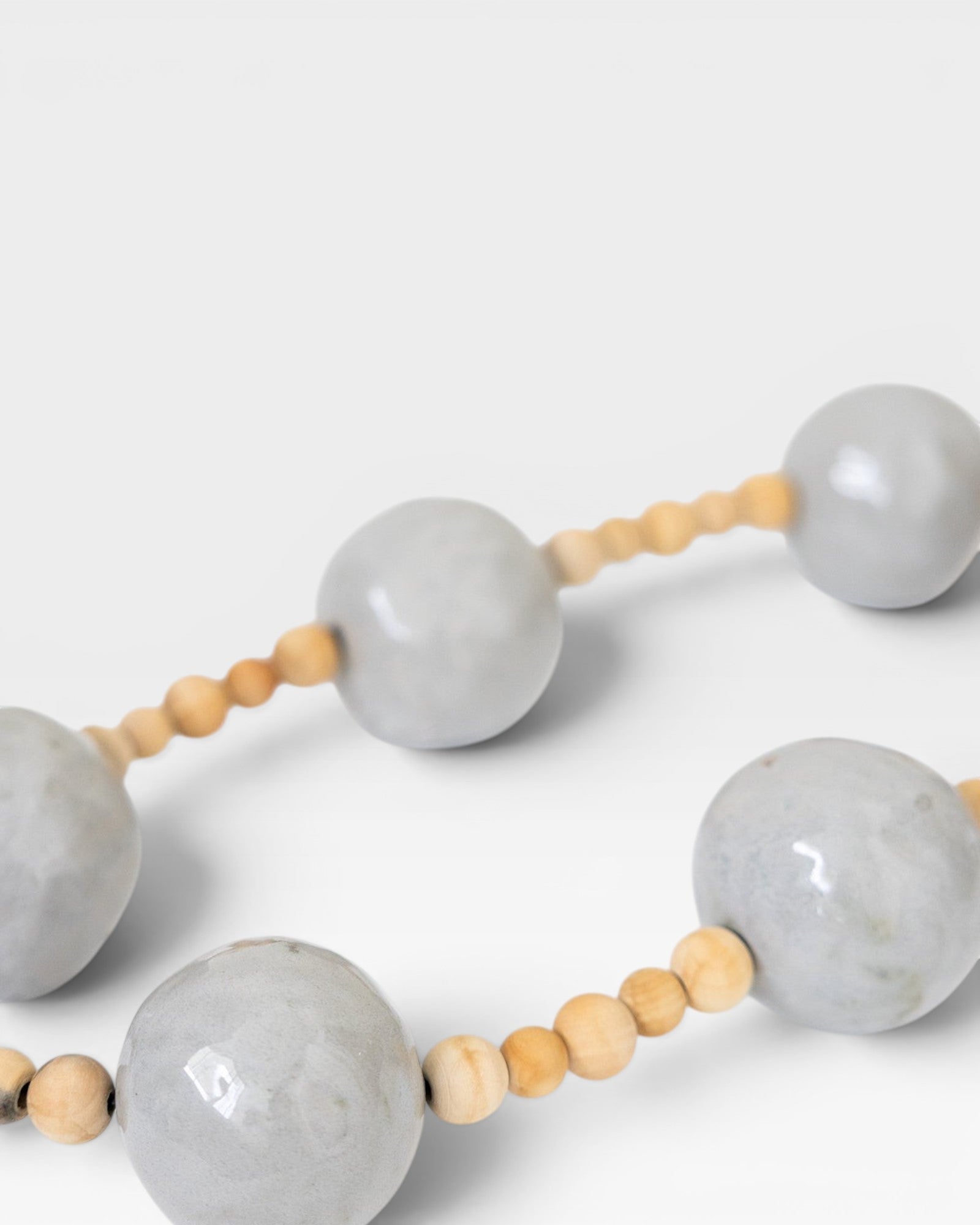 JONES + CO handcrafted wall art with large grey pottery beads and small wooden beads, bringing spiritual elegance to any space.