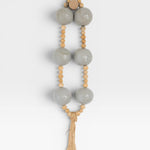 JONES + CO grey pottery and wood hanging wall mala beads with tassel.