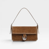 JONES + CO Harlow shoulder bag in cigar brown suede with whipstitch trim and signature silver Moon buckle hardware.