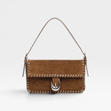 JONES + CO Harlow shoulder bag in cigar brown suede with whipstitch trim and signature silver Moon buckle hardware.