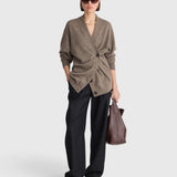 JONES + CO hazelnut cashmere-silk cardigan with draped button detail worn by a model with black trousers and bag