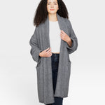 Model wearing a JONES + CO heather grey baby alpaca sweater coat with dropped shoulders and front pockets.