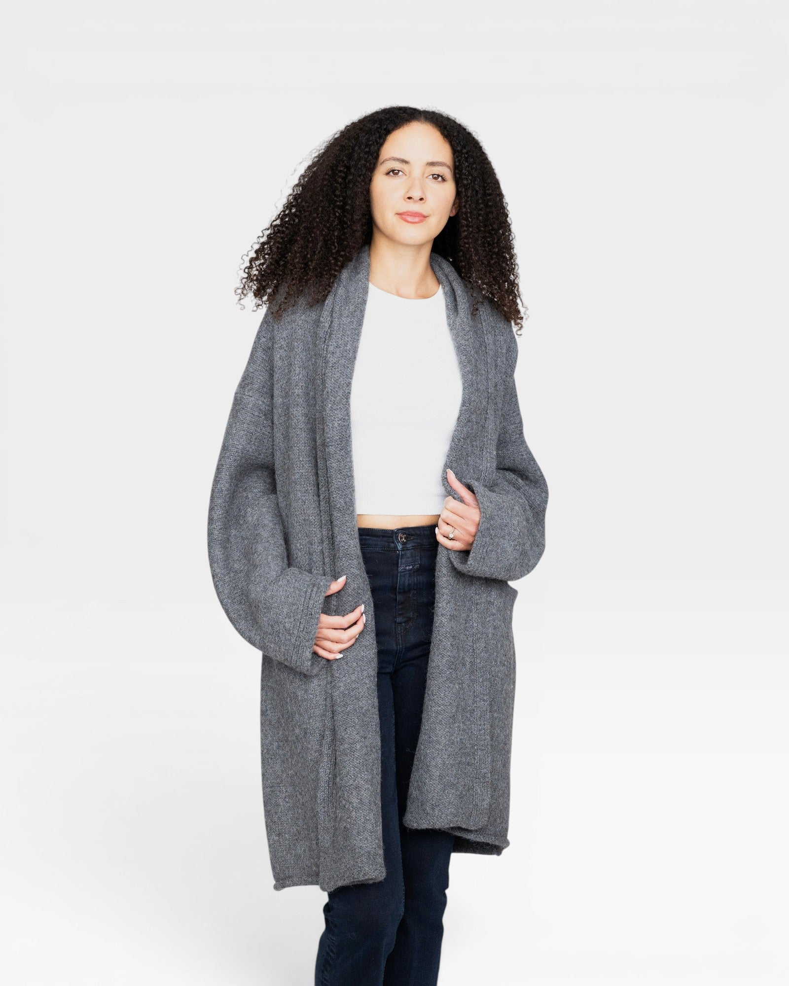 Model wearing a JONES + CO heather grey baby alpaca sweater coat with dropped shoulders and front pockets