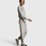 Model wearing JONES + CO heather grey cotton fleece track pants with ivory side stripes and drawstring waist