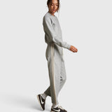 Model wearing JONES + CO heather grey cotton fleece track pants with ivory side stripes and drawstring waist