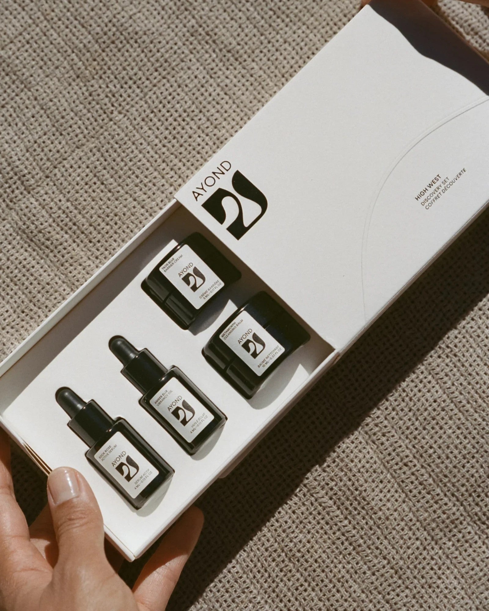 JONES + CO High West Discovery Set featuring four small dark glass bottles with dropper and cap tops, containing skincare serums and balms.