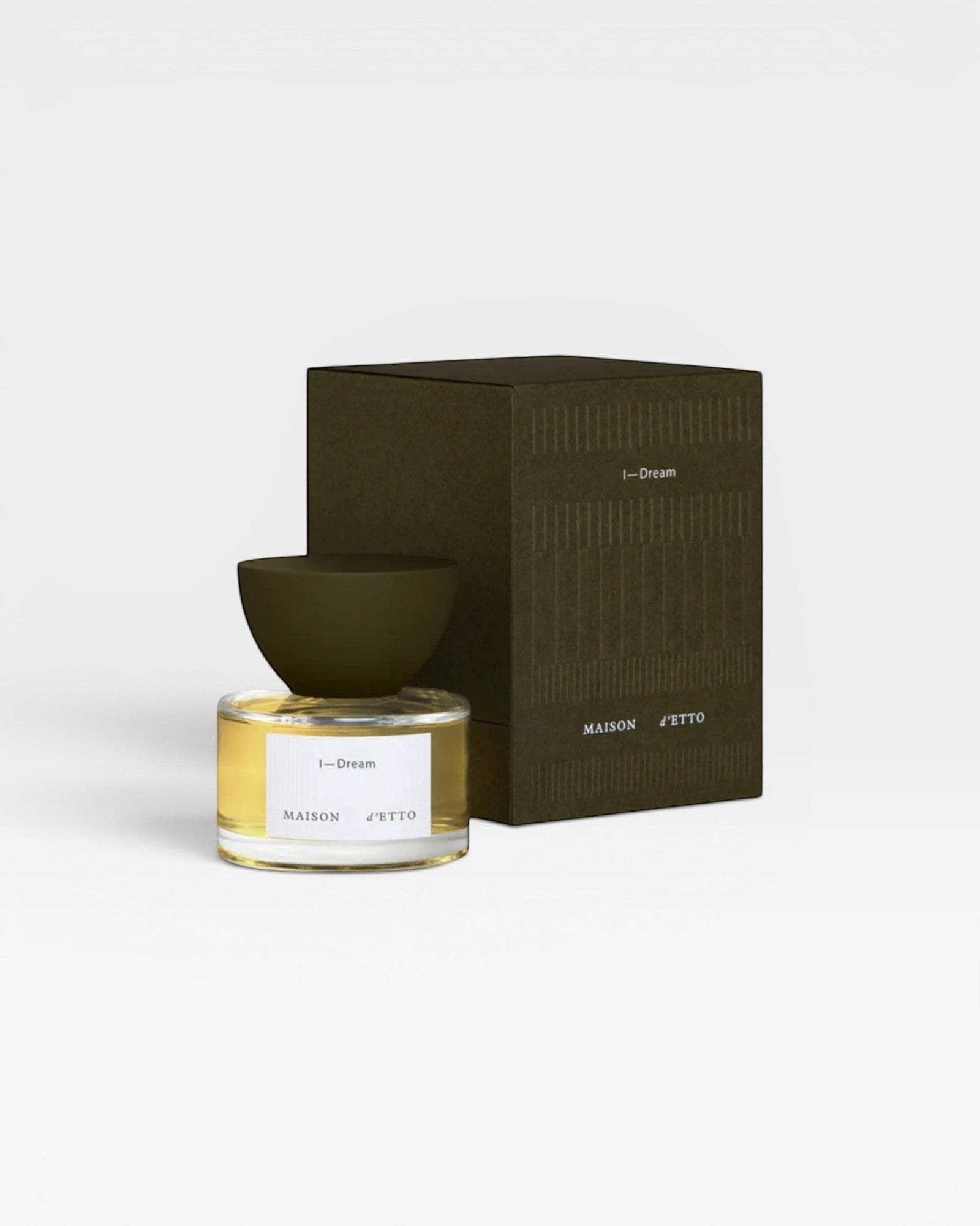 JONES + CO I-Dream Eau de Parfum, a neo-gourmand fragrance with notes of carrot seed, cypress, and vanilla in a clear glass bottle with a dark green cap and box.