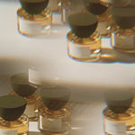 JONES + CO I—Dream Eau de Parfum in clear glass bottles with dark caps, featuring a golden liquid.