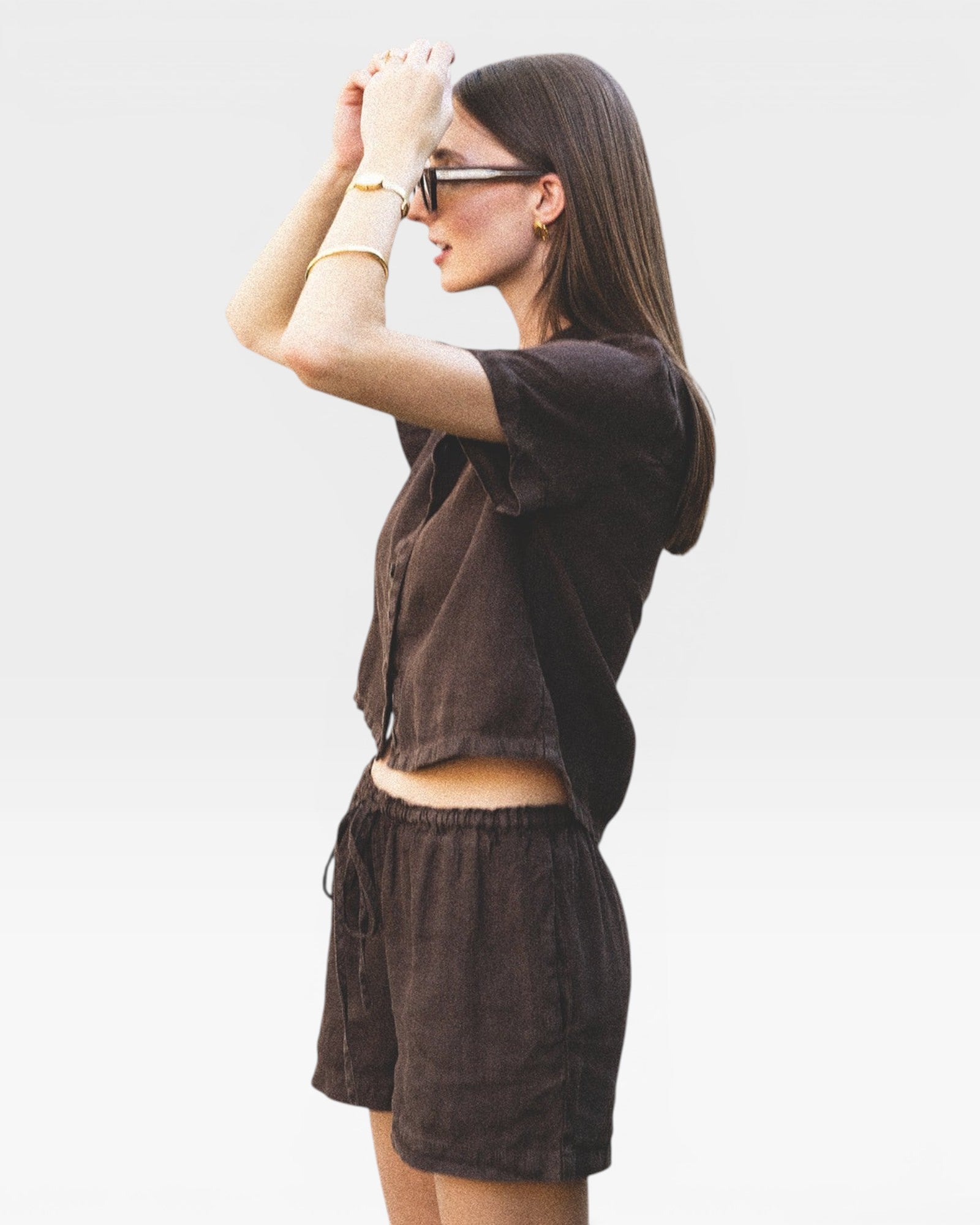 JONES + CO Ida Linen Short in chestnut brown, featuring a drawstring waist and relaxed fit. Model wears sunglasses and jewelry.