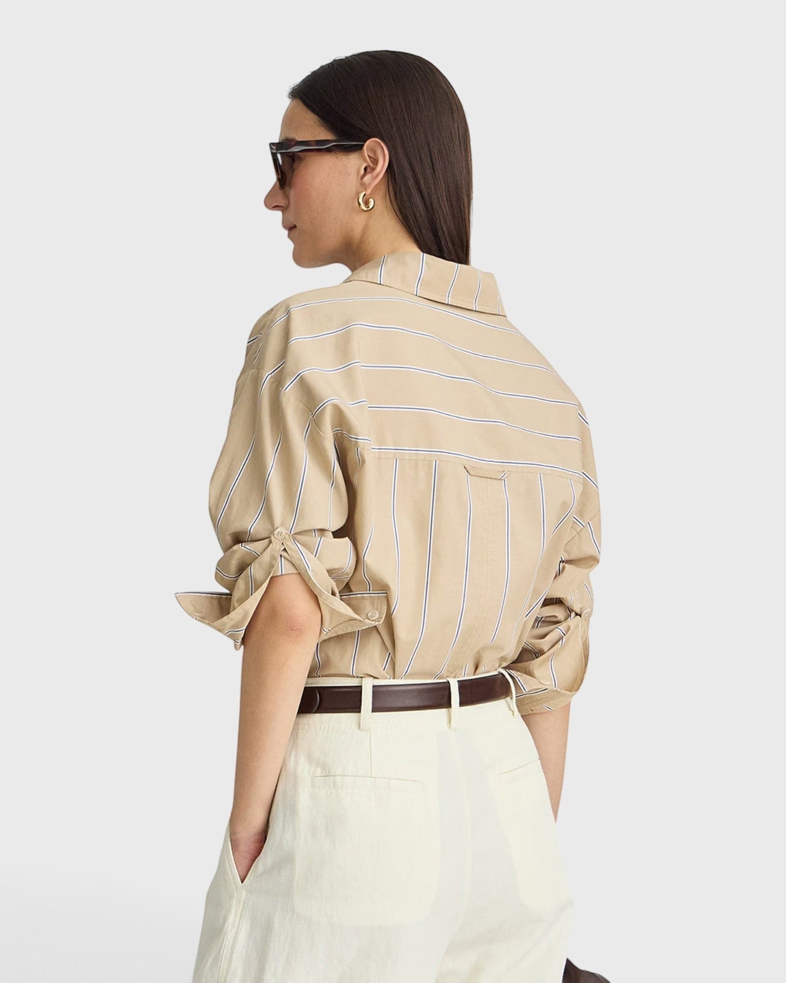 JONES + CO Isolde button-down shirt in sand and blue stripe with dropped shoulders and rolled sleeves, back view.