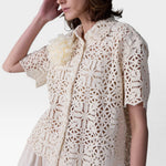 JONES + CO ivory cotton lace short sleeve oversized button-down shirt with floral pattern and detachable flower accent.