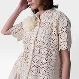 JONES + CO ivory cotton lace short sleeve oversized button-down shirt with floral pattern and detachable flower accent.