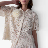 JONES + CO ivory cotton lace short sleeve oversized button-down shirt with floral crochet and detachable flower accent.