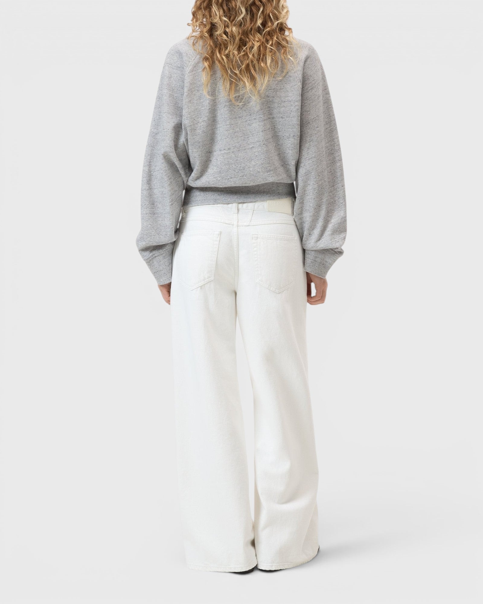 JONES + CO Jayla ivory wide-leg rigid denim jeans with a mid-rise waist and five-pocket design, back view.