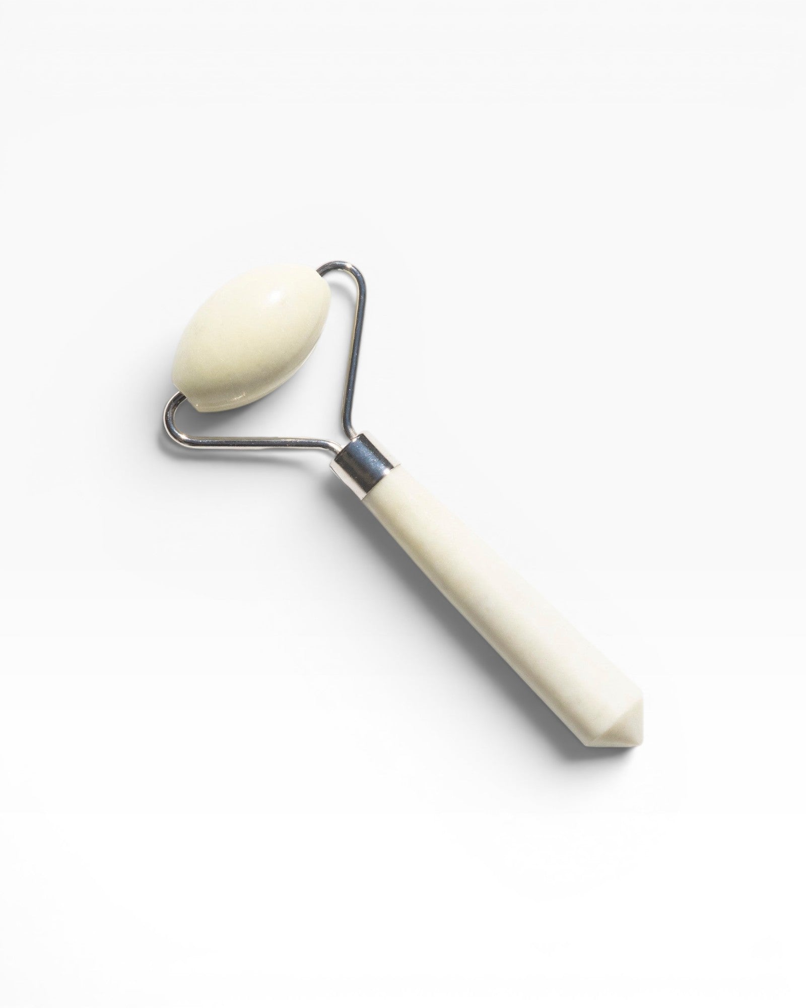 JONES + CO jade roller with a cream-colored stone and handle, designed to depuff and improve circulation.