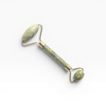 JONES + CO jade roller for depuffing and improving circulation. Features a green jade stone and gold-tone metal.