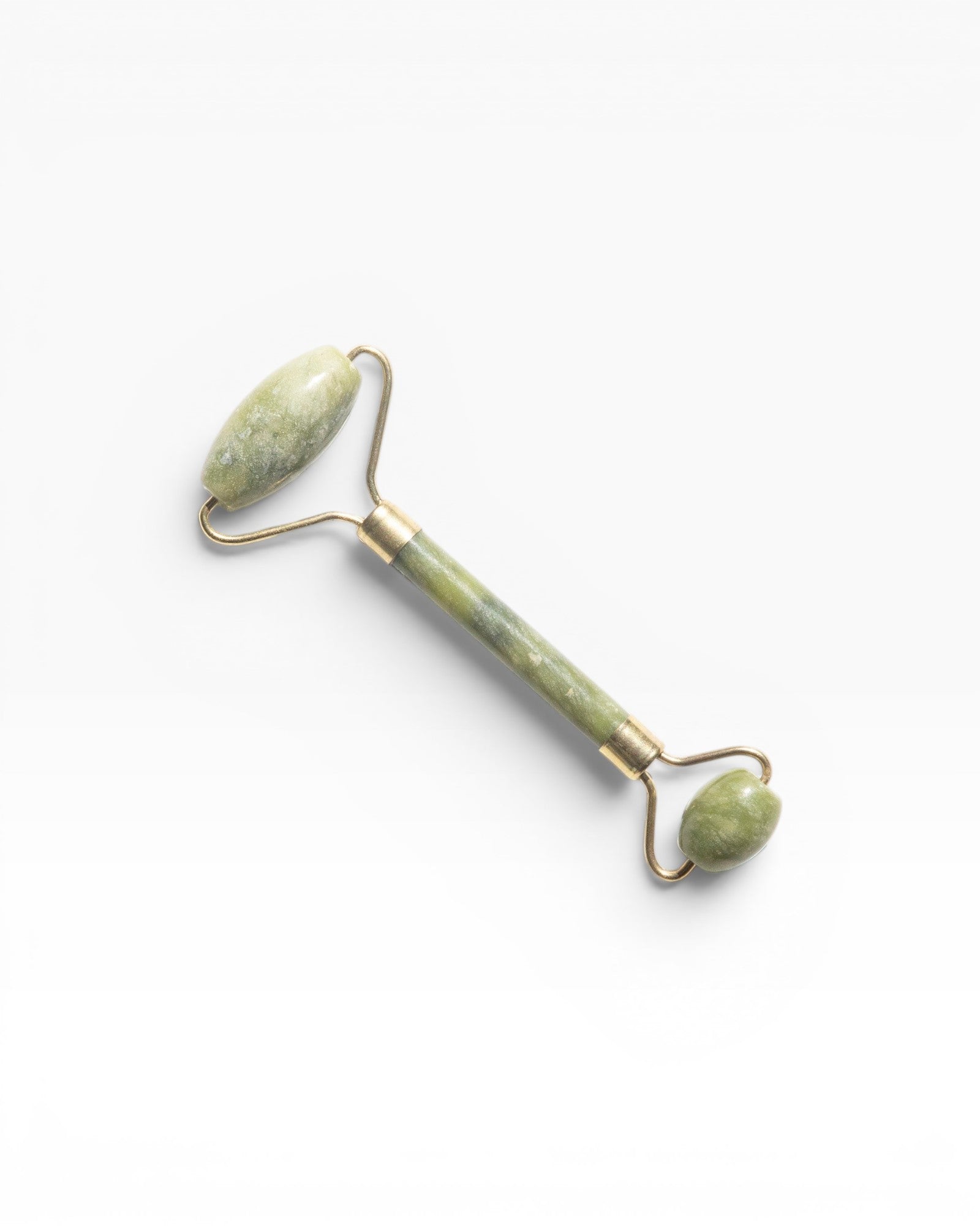 JONES + CO jade roller for depuffing and improving circulation. Features a green jade stone and gold-tone metal.