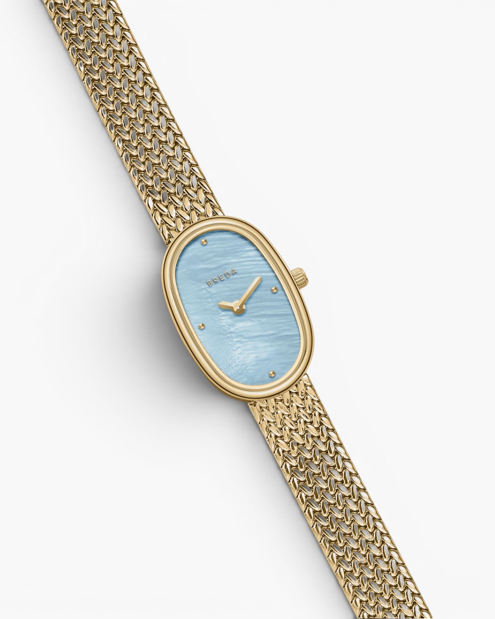 JONES + CO Jane Small watch with a gold oval case, sky blue mother of pearl dial, and woven gold mesh bracelet.